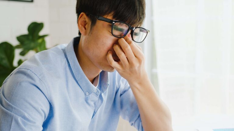 A close-up of an individual rubbing their itchy eyes.