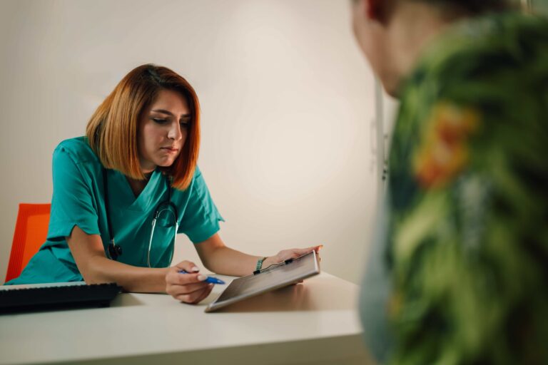 A patient filling out paperwork at an urgent care reception desk