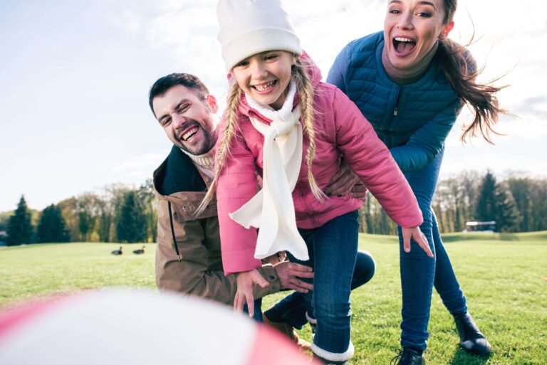 happy-family-playing-with-ball-on-green-meadow