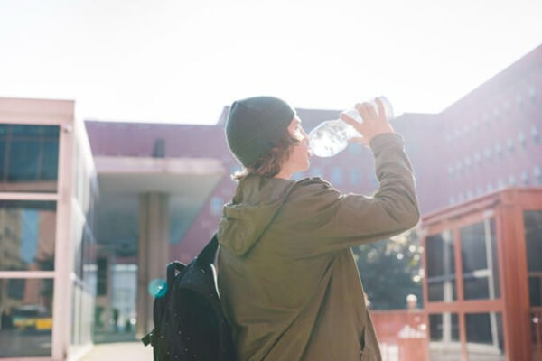 Person drinking water outside a building