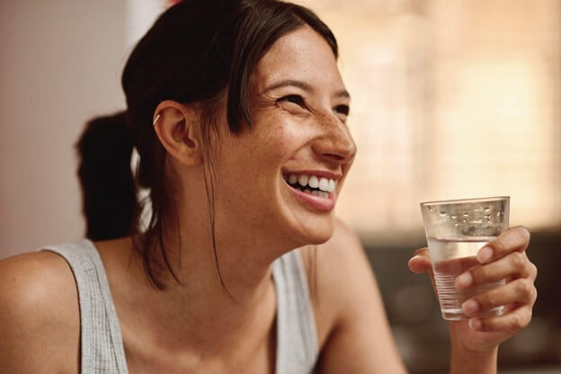 Woman smiling and drinking water
