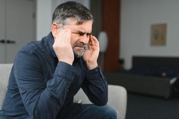 man in a room having headache