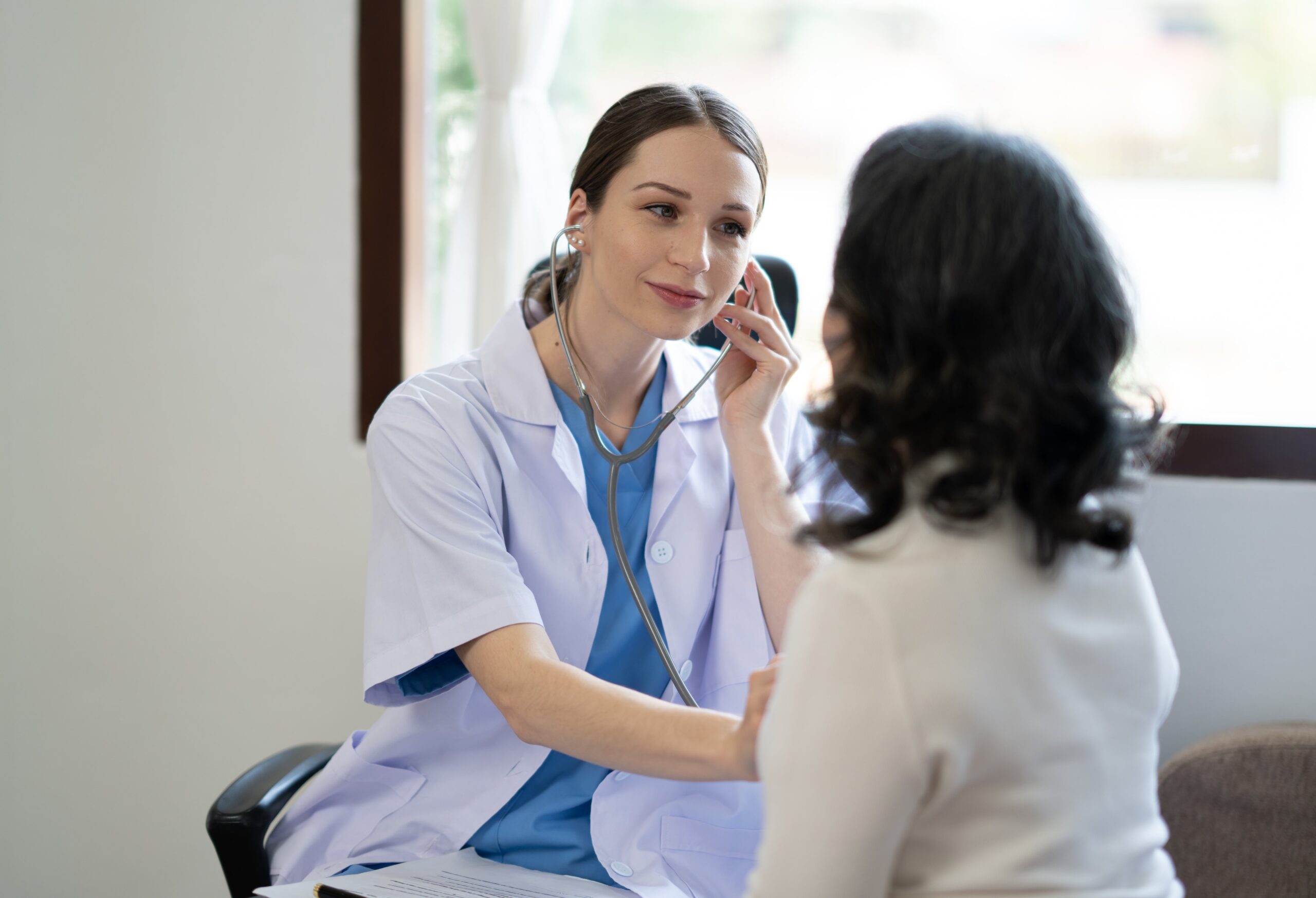 caucasian-famale-doctor-sit-on-chair-check-asian-s-2025-01-10-06-00-37-utc-min