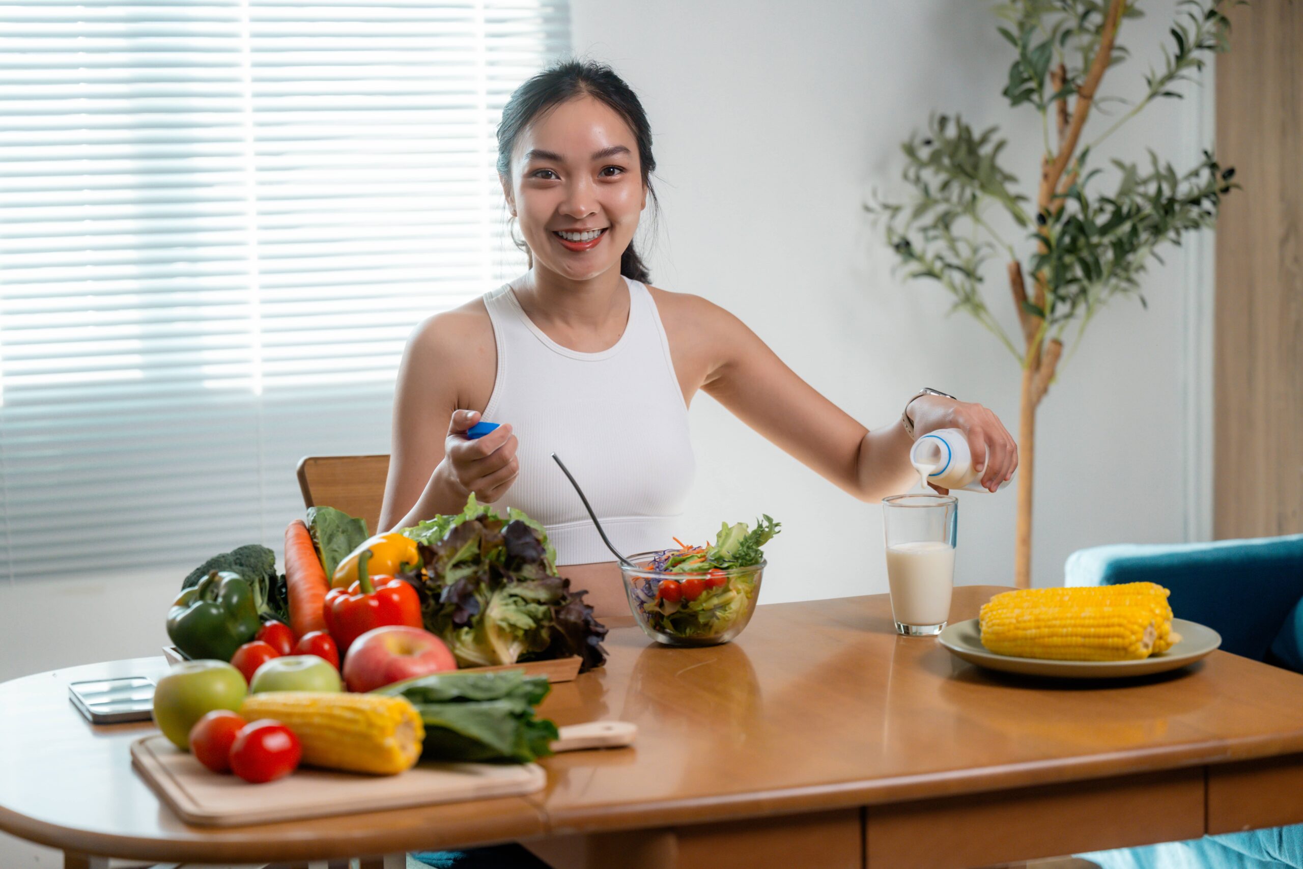 young-woman-pouring-milk-into-glass-eating-healthy