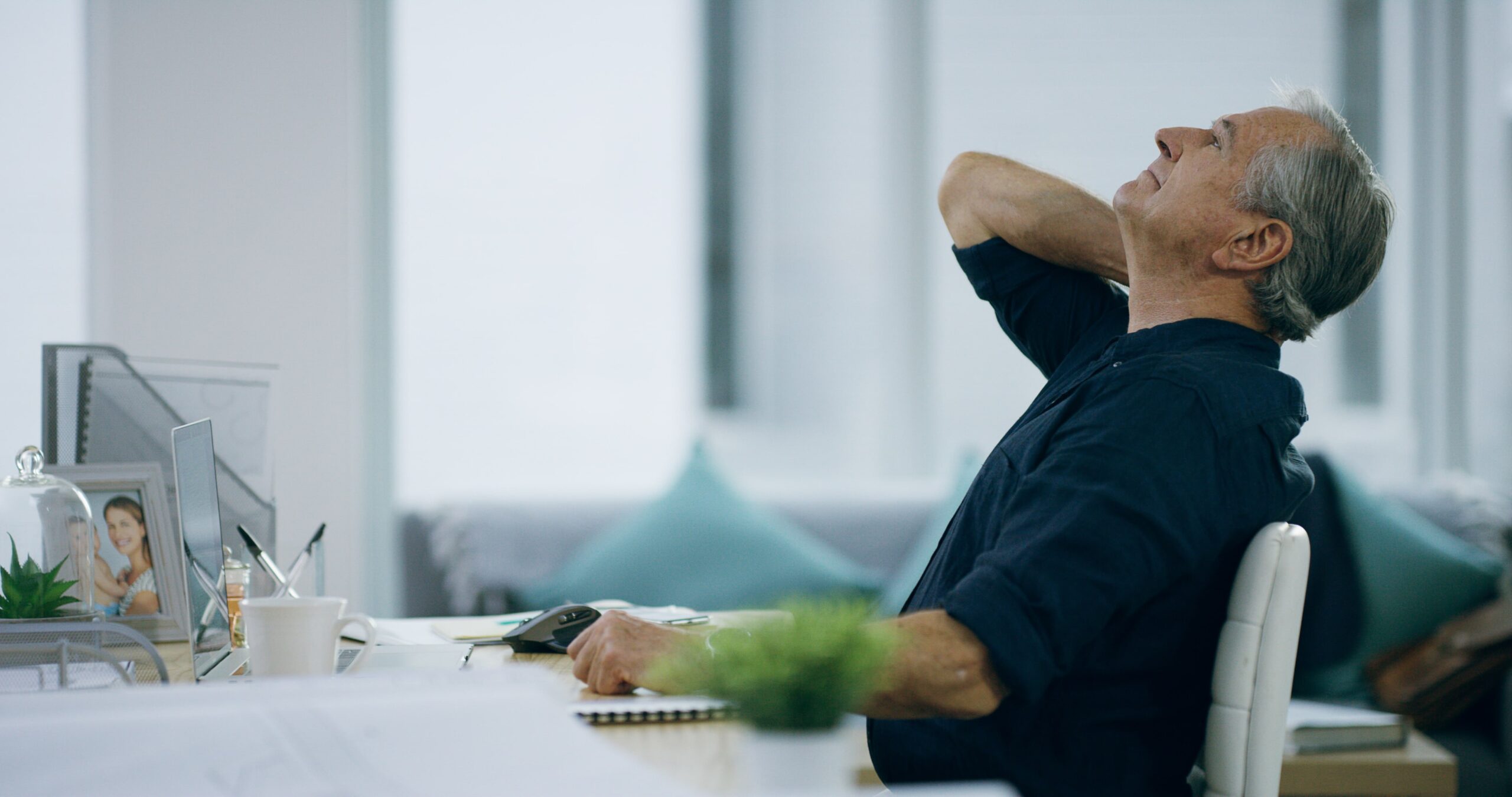 A senior man experiencing neck pain from strain, poor posture, or joint inflammation while working at home.