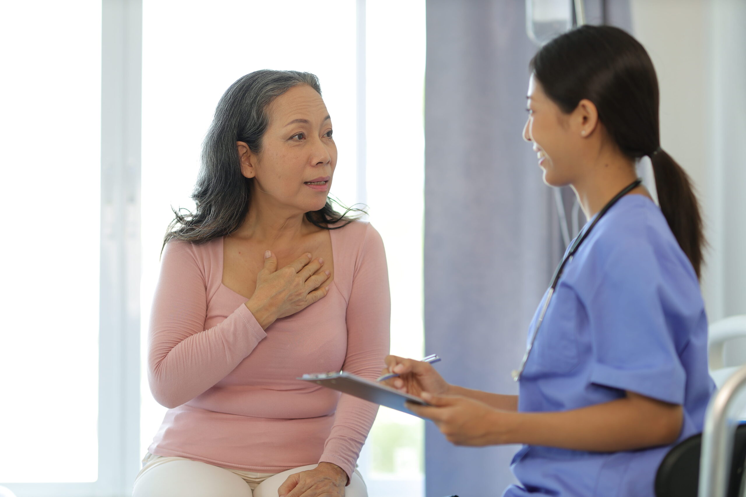 A patient speaking calmly with a healthcare provider in a well-lit exam room.