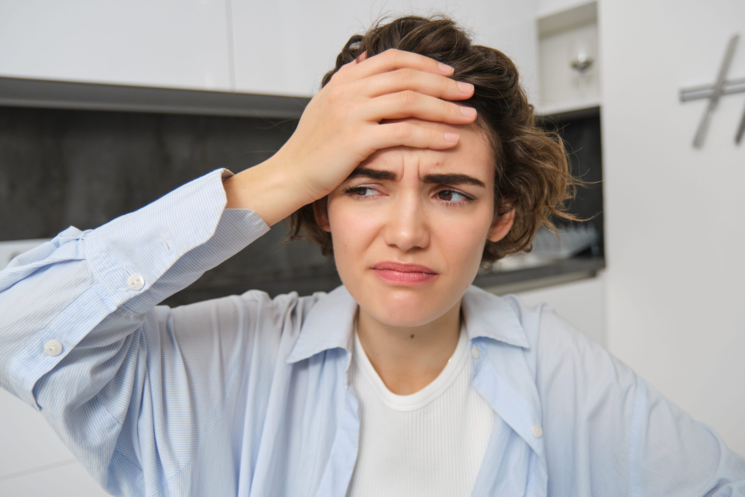 portrait-woman-with-mgiraine-girl-grimaces-from-painful-headache-touches-her-head-frowns-from-discomfort-sits-home