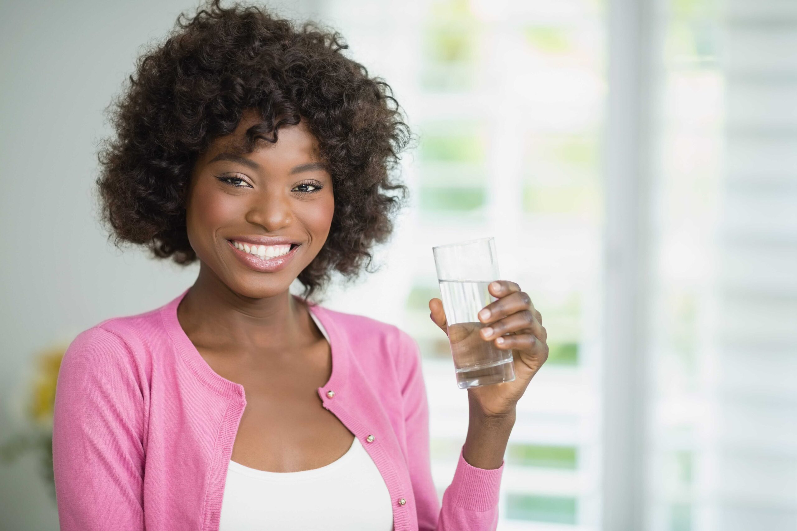 A woman is having a glass of water.